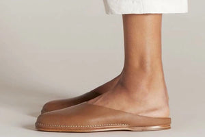 Authentic handmade shoes featuring minimalist brown leather slip-ons with a stitched sole.