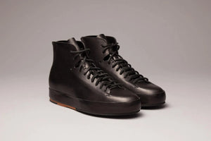  Leather sneakers in matte black with minimalist design and natural sole finish.
