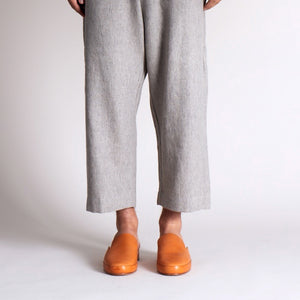 Leather mule shoes in a warm tan shade styled with cropped gray pants.